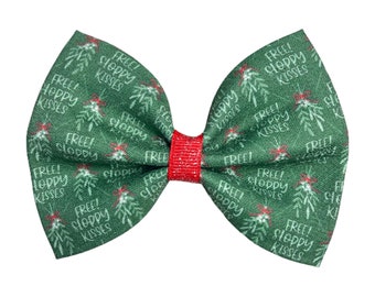 May include: A green bow with a white print that says "Free Sloppy Kisses" and a red glitter center.