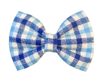 May include: A blue and white plaid bow tie. The bow tie is made of a soft, textured fabric.