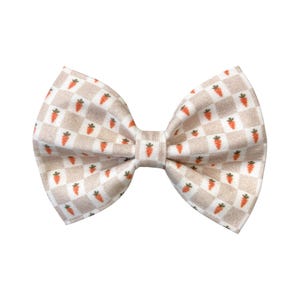 May include: A beige bow tie with a checkered pattern and orange carrot illustrations.