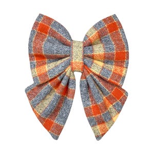 Orange and gray plaid dog bow tie or cat bow tie on a white background. Two Velcro straps are sewn on to the back.