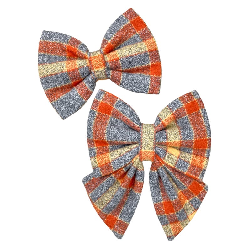 Orange and gray plaid dog bow tie or cat bow tie on a white background. Two Velcro straps are sewn on to the back.