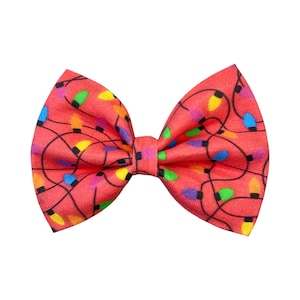 May include: A red bow tie with a pattern of colorful Christmas lights.