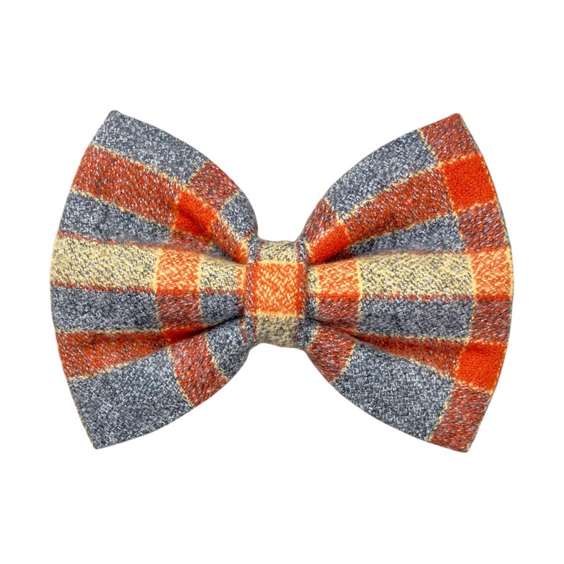 Orange and gray plaid dog bow tie or cat bow tie on a white background. Two Velcro straps are sewn on to the back.