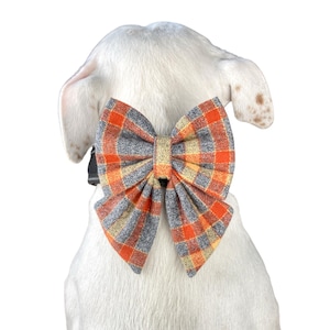 Orange plaid dog bow tie or cat bow tie is attached to a dogs collar with two Velcro straps.