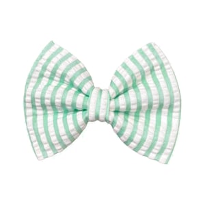 May include: A green and white striped fabric bow with a knotted centre.