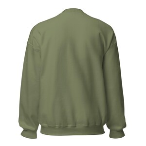 May include: A solid olive green crewneck sweatshirt shown from the back. The garment features long sleeves with ribbed cuffs, a ribbed hemline, and a ribbed collar. The fabric has a smooth, consistent texture throughout the entire back panel.