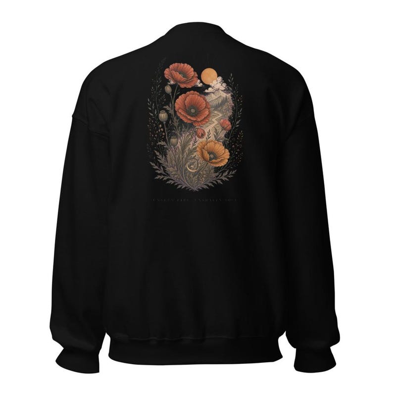 May include: A black crewneck sweatshirt featuring a detailed graphic on the back. The illustration depicts vibrant red and orange poppy flowers, foliage, a winding path, and a circular sun set against a dark, textured background.