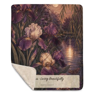 May include: A rectangular throw blanket with a sherpa fleece underside and a printed top featuring purple and white iris flowers by a moonlit river. The text reads "us &middot; Living Beautifully" and "DIAGNOSIS COLLECTION" on a light rectangular patch.