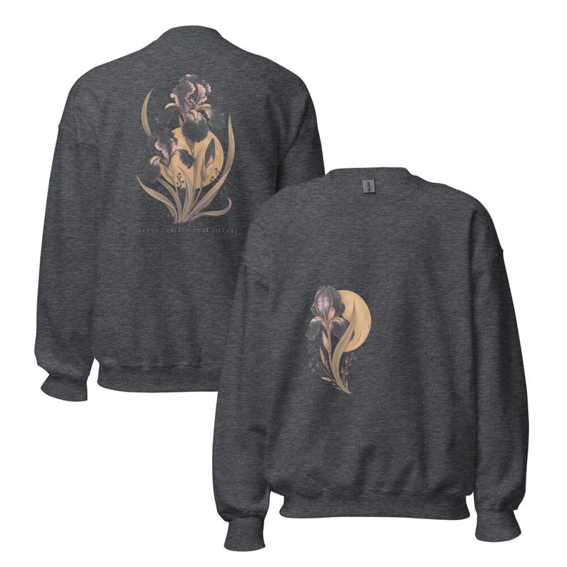 May include: A dark heather grey crewneck sweatshirt featuring a graphic of a dark purple iris flower layered over a pale yellow moon. The back of the sweatshirt displays a larger version of the same floral design with the text "LOVING FEELING HERE I STAY".