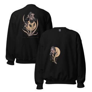 May include: A black crewneck sweatshirt featuring a graphic of a dark iris flower against a pale yellow moon. The back displays a larger version of the same floral design with the text "IRIS - LIVING BEAUTIFULLY" printed in small, clean lettering below it.