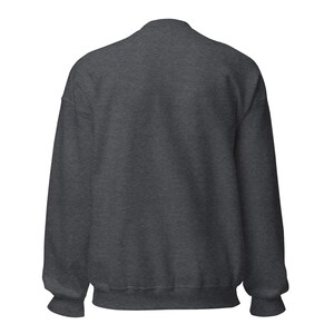 May include: A dark heather gray long-sleeve crewneck sweatshirt featuring a solid, plain back view. The garment is constructed with ribbed cuffs at the wrists and a ribbed hem at the waist, showcasing a consistent, textured fabric throughout the piece.