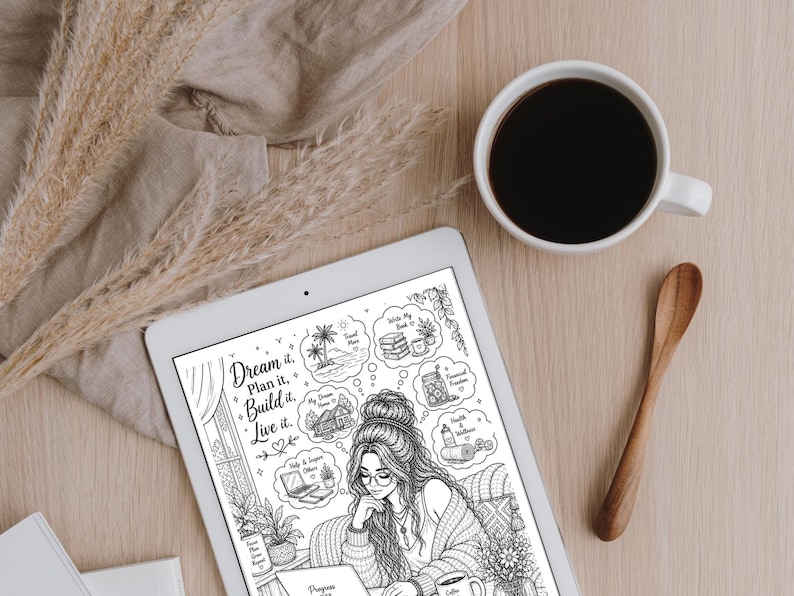 May include: A white tablet displaying a black and white illustration of a woman with thought bubbles. The bubbles contain images of a house, a beach, and other items. A cup of coffee and a wooden spoon sit on a light wood surface. Dried plants and a tan cloth are also present.