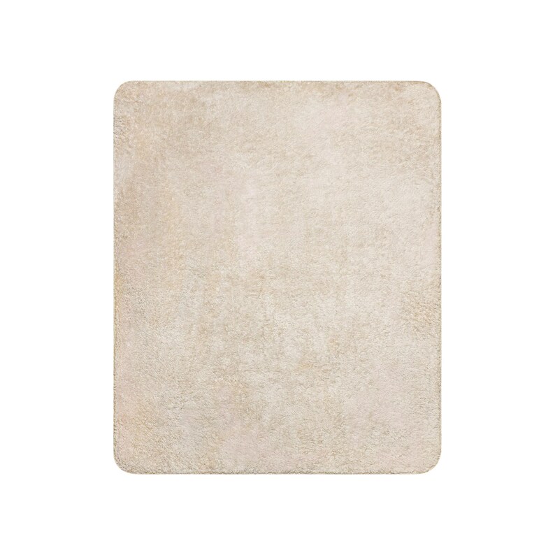 May include: A rectangular, solid beige blanket with a soft, plush, and fuzzy texture. The item features rounded corners and a consistent, uniform light tan color throughout its entire surface, presenting a simple and clean appearance.