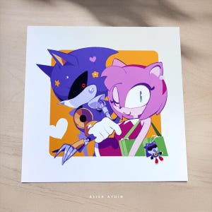 Puede incluir: Impresión artística cuadrada con dos personajes de dibujos animados, uno morado y otro rosa, abrazándose sobre un fondo naranja. El personaje morado tiene una apariencia robótica. El personaje rosa sostiene una bolsa verde. El texto "ALISA AYDIN" está en la parte inferior.