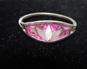 May include: A silver ring with a pink enamel design and a white mother-of-pearl flower in the center.