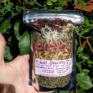 Puede incluir: Una bolsa de plástico transparente llena de una mezcla de hierbas y flores secas. La bolsa está etiquetada como "Sweet Stability" y enumera los ingredientes: baya de schisandra, raíz de astrágalo, bálsamo de limón, ortiga, regaliz, hierba limón, pétalo de rosa. El texto también incluye el sitio web "GeWithNature.etsy.com".