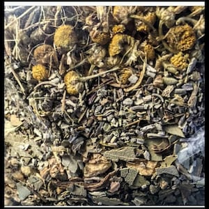 May include: A close-up of a mixture of dried herbs and flowers, including lavender, chamomile, and eucalyptus. The mixture is a light brown color with hints of purple and green.