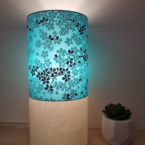 Lampe à poser cylindrique en papier japonais fleurs de cerisiers sur fond bleu et petits points dorés