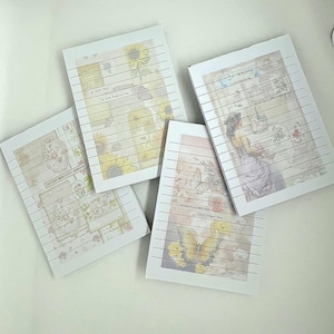 Puede incluir: Una colección de blocs de notas rayados con ilustraciones florales y de mariposas de estilo vintage. Cada bloc de notas presenta un diseño diferente, incluyendo girasoles, una mujer con un vestido y varios arreglos florales. Los blocs de notas tienen texto impreso.