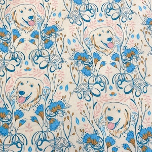May include: White fabric with a repeating pattern of golden retrievers and blue flowers. The dogs are facing forward and have brown noses. The flowers are stylised and have a blue and white colour scheme.