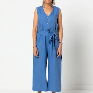 May include: A blue linen jumpsuit with a button-up front, a tie belt, and pockets. The jumpsuit has a wide-leg silhouette and is cropped above the ankle.