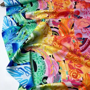 May include: A colourful fabric with a rainbow gradient pattern. The fabric features abstract shapes, flowers, and leaves in shades of blue, green, yellow, orange, pink, and red.