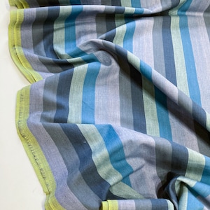 May include: Striped fabric in shades of blue, green, and grey. The fabric has a subtle texture and a soft, drapey feel.