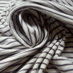 May include: Close-up of a white and brown striped fabric with a soft, textured feel.