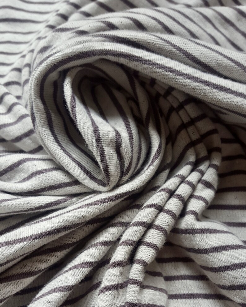 May include: Close-up of a white and brown striped fabric with a soft, textured feel.