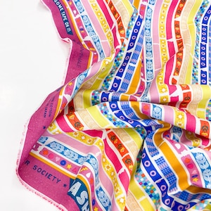 May include: Brightly coloured fabric featuring vertical stripes in pink, yellow, blue, and orange. The stripes are adorned with diverse patterns, including flowers, circles, and geometric shapes. The fabric has text that reads "UT SOME TAPE ON IT!" and "ASAHI PI".