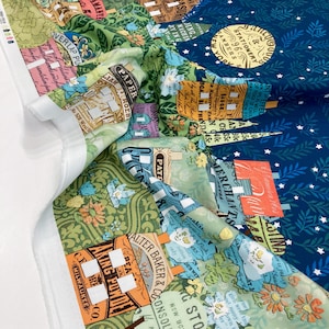 May include: A patterned fabric with a vintage-inspired design. The fabric features a collage of illustrations in shades of green, blue, orange, and white, with text and floral motifs. The design includes a night sky with stars and a moon.
