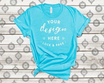 Download Free Turquoise Bella Canvas 3001 Winter T-Shirt Mockup Festive Xmas Tee Shirt On Christmas Tree Baubles Balls Wooden Background PSD Template