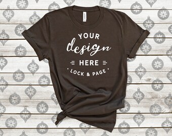 Download Free Brown Bella Canvas 3001 Winter T-Shirt Mockup Festive Xmas Tee Shirt On Christmas Tree Baubles Balls Wooden Background PSD Template