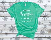 Heather Kelly Bella Canvas 3001 Winter T-Shirt Mockup Festive Xmas Tee Shirt On A Snowflake Patterned Wooden Background