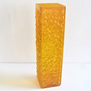 May include: A tall, amber-colored glass vase with a textured, bubble-like surface.