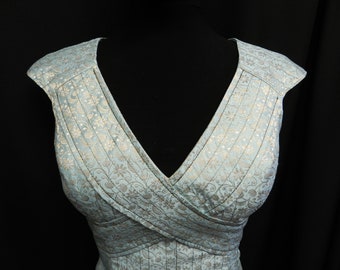 May include: A light blue sleeveless dress with a V-neckline and a floral pattern. The dress has a fitted bodice and a flowing skirt.