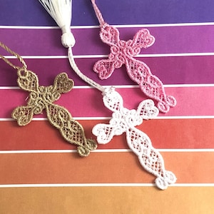 Op de afbeelding: Drie delicate kant-kruis-bladwijzers in goud, wit en roze. Elke bladwijzer heeft een kwastje aan de bovenkant.