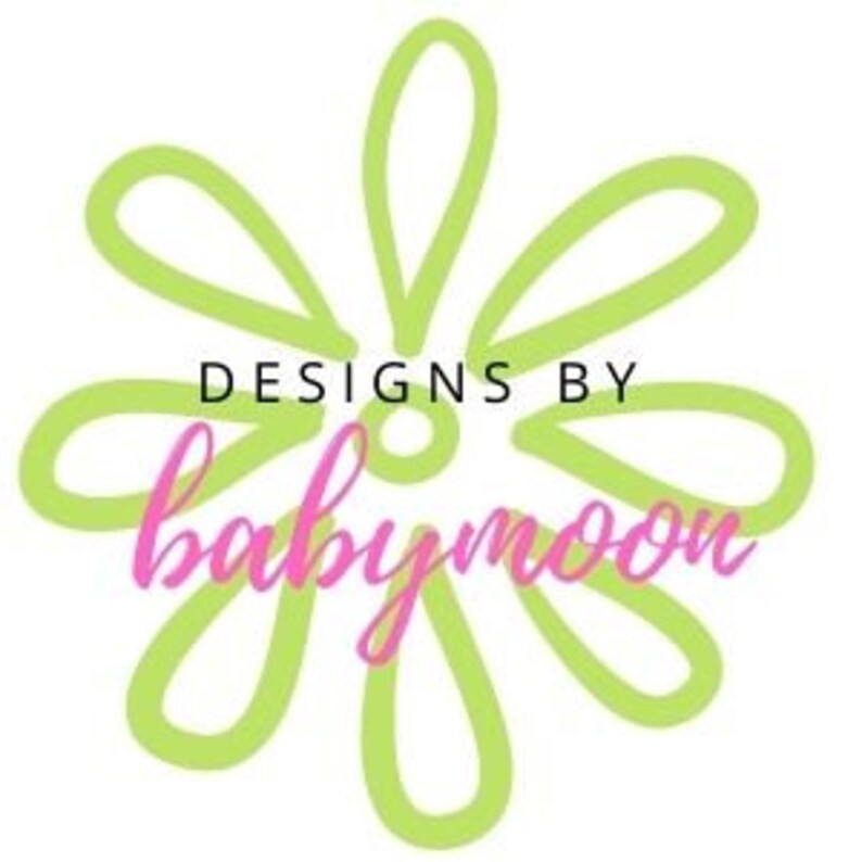 May include: A green daisy with a pink "Designs by Babymoon" logo in the center.