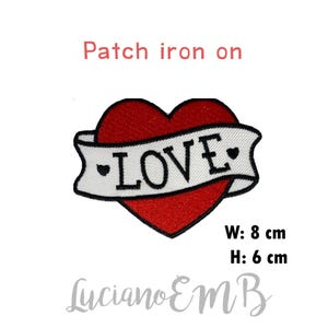 Könnte beinhalten: Gestickter Aufnäher mit einem roten Herz und einem weißen Banner mit dem schwarzen Schriftzug "LOVE". Der Aufnäher ist 8 cm breit und 6 cm hoch. Der Text "Patch iron on" steht über dem Herz.