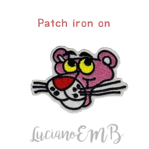 Può includere: Toppa termoadesiva della Pantera Rosa con occhi gialli, naso rosso e baffi bianchi. La toppa ha un bordo bianco. Il testo sopra dice "Patch iron on". Il testo "Luciano EMB" è sotto.