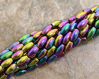 Peut inclure: Un brin de perles d'hématite ovales irisées dans des tons de vert, violet, or et noir.
