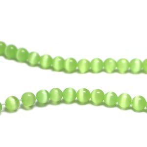Può includere: Una collana di perle occhio di gatto verde chiaro. Le perle sono rotonde e hanno una finitura liscia e lucida.