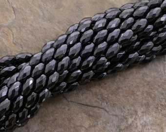 Peut inclure: Un brin de perles d'hématite facettées noires. Les perles sont de forme ovale et ont une finition brillante.
