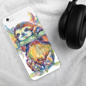 May include: A colorful watercolor painting of a sloth hanging from a branch. The sloth is painted in shades of yellow, orange, green, and blue. The background is white.