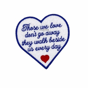 May include: Blue heart-shaped embroidered patch with a white background and the text "Those we love don't go away they walk beside us every day". A small red heart is in the centre of the patch.