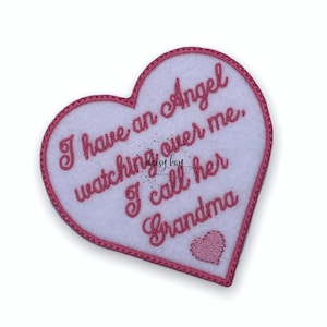 Può includere: Toppa di feltro rosa a forma di cuore con ricamo bianco che recita "Ho un angelo che veglia su di me. La chiamo nonna".