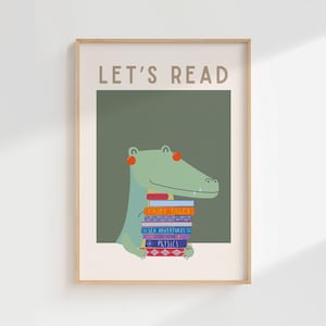 Peut inclure: Une affiche encadrée représentant un alligator de dessin animé tenant une pile de livres. L'affiche porte l'inscription « LET'S READ » en haut. L'alligator est vert avec des détails orange, et les livres sont de couleurs variées. Le fond est vert.