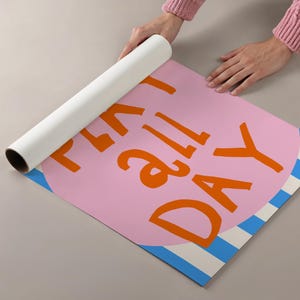 May include: A rolled-up poster with the words "PLAY ALL DAY" in orange letters on a pink circle. The poster has a blue and white striped border and is being unrolled by a person.