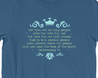 May include: A blue t-shirt with a light blue design featuring a crown and text that reads: "For thou art an holy people unto the Lord thy God: the Lord thy God hath chosen thee to be a special people unto himself, above all people that are upon the face of the earth. Deuteronomy 7:6"