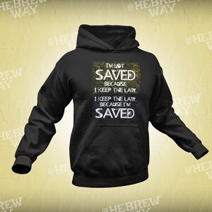 May include: Black hoodie with a white and yellow graphic print that says "I'm not saved because I keep the law. I keep the law because I'm saved."